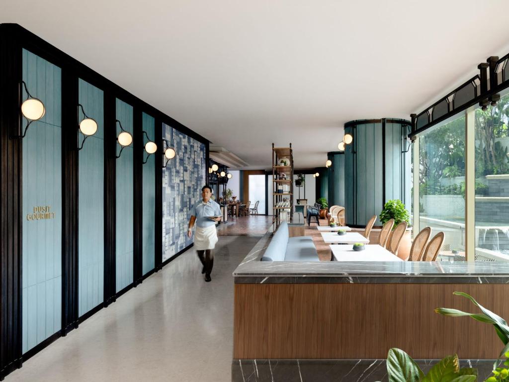 a person walking down a hallway in a building at Dusit Thani Bangkok in Bangkok