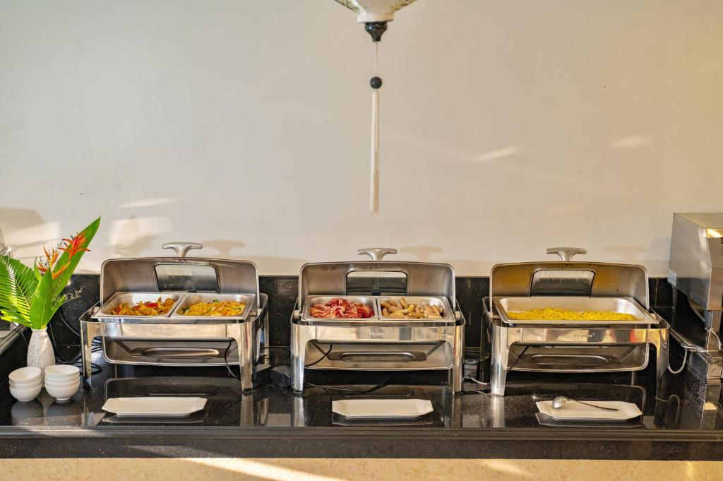 a buffet with four trays of food on a counter at Athenia Hoi An Boutique Hotel & Spa in Hoi An