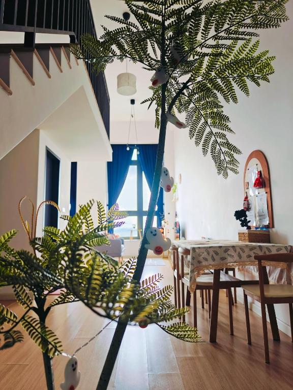 a living room with a palm tree and a table at Sunway Grid Loft Suite by Chill Lah Home in Iskandar Puteri