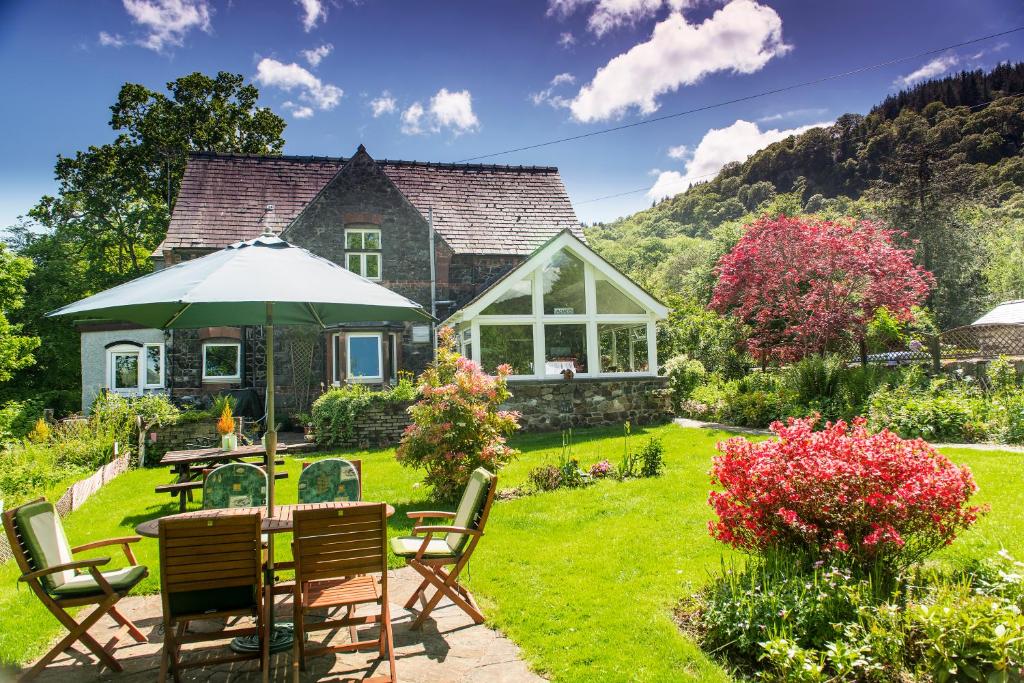 a garden with a table and chairs and a house at The Courthouse in Betws-y-coed
