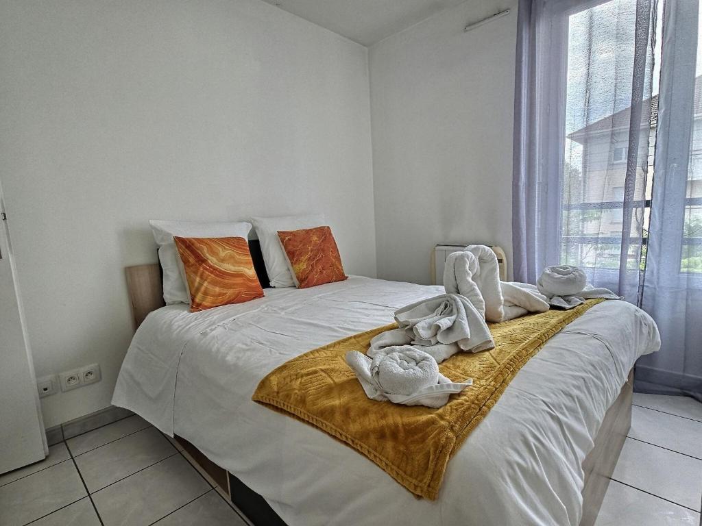 ein Schlafzimmer mit einem Bett mit Handtüchern darauf in der Unterkunft Très bel appartement entre Paris et Disneyland in Lognes