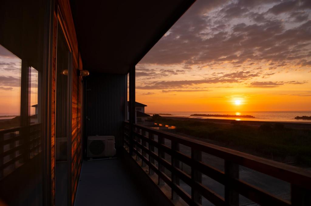 a sunset from the balcony of a house at 最高の日の出をTakahagi Base in Takahagi