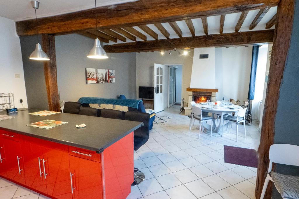 a kitchen and living room with a table and a couch at Maison en Pays d'Othe in Les Sièges