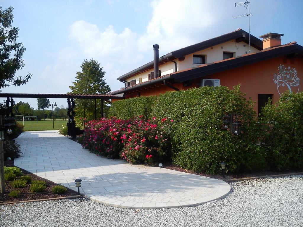 a house with a garden with flowers in front of it at Country House La Perla del Sile in Sant'Elena di Silea