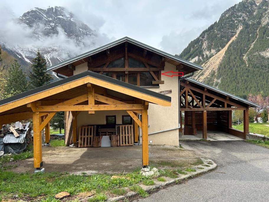 un grand bâtiment avec une flèche rouge pointant vers une montagne dans l'établissement Studio 4p Louedza, à Pralognan-la-Vanoise
