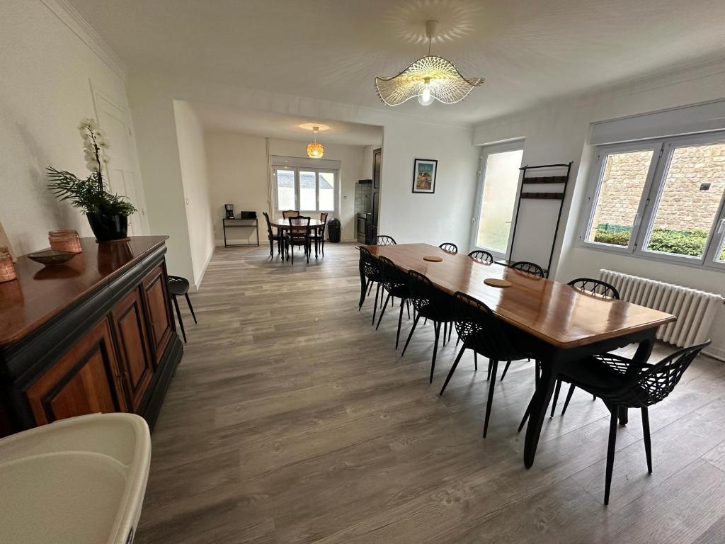 une salle à manger avec une longue table et des chaises dans l'établissement Gite Bonheur du Pré-Salé, à Pontorson