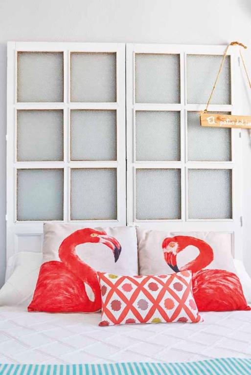 a bed with two red flamingos on top of it at El Patio del Limonero in Écija