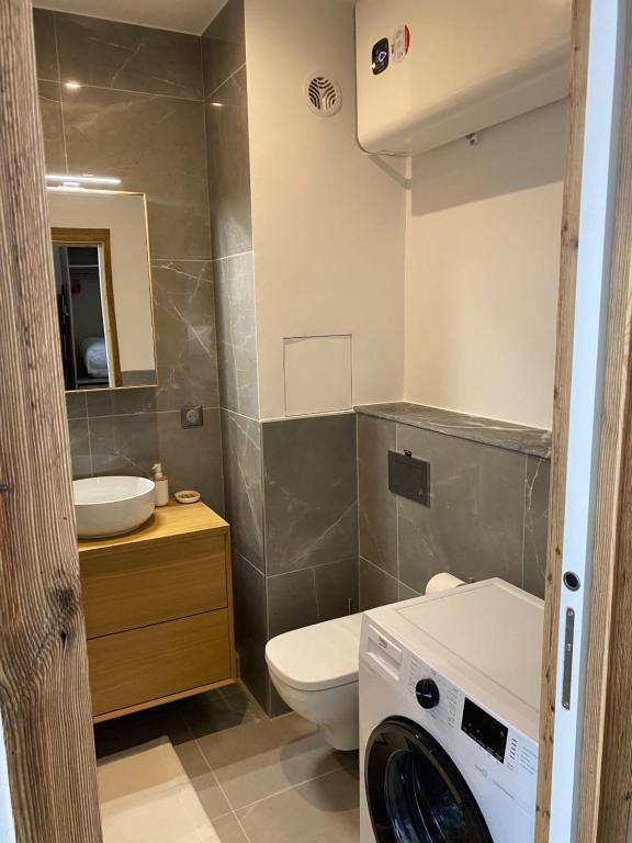 La salle de bains est pourvue de toilettes, d'un lavabo et d'un lave-linge. dans l'établissement Escapade scandinave aux Menuires, aux Menuires