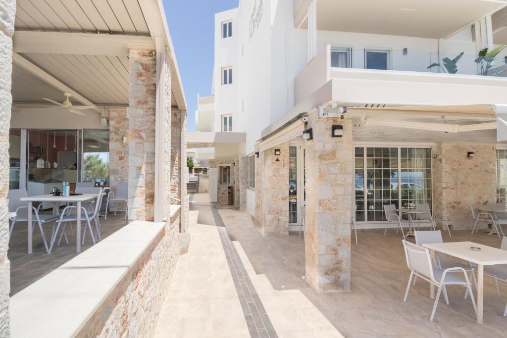 an outdoor patio with tables and chairs and a building at Pal Beach in Palaiochora