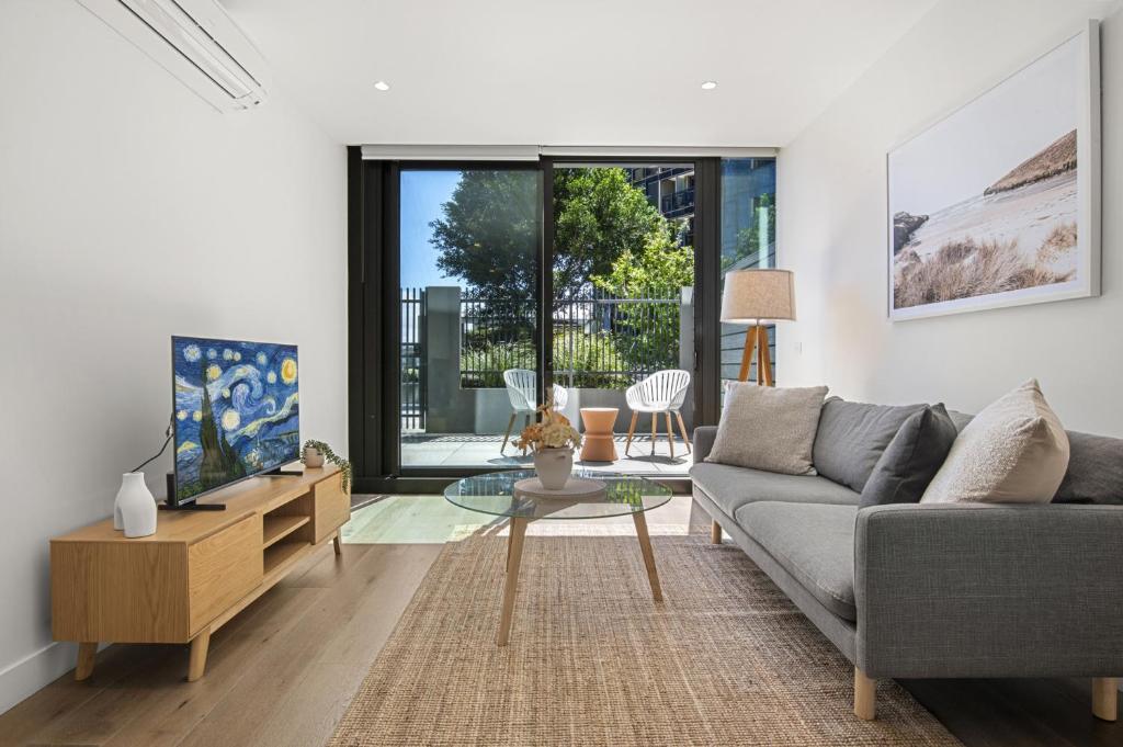 a living room with a couch and a table at Fabulous 1-Bed with Pool and Private Courtyard DUPLICATE in Melbourne