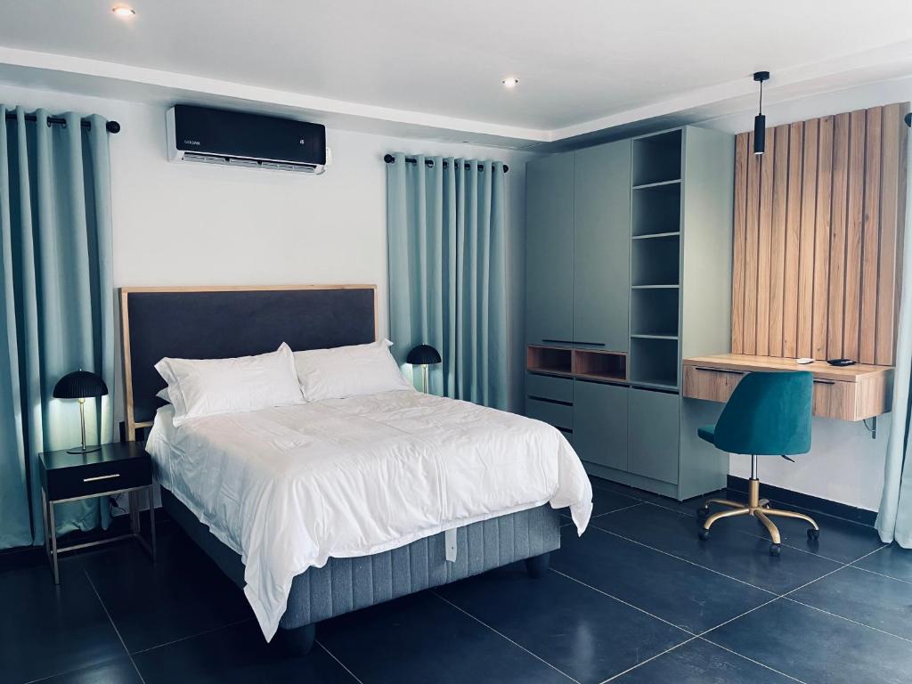 una camera con letto, scrivania e sedia di ANG COMSAT Guesthouse a Northam