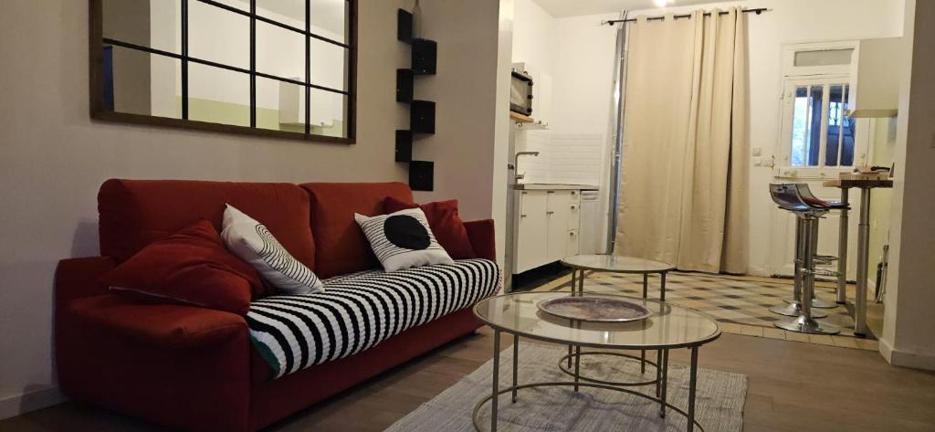 - un salon avec un canapé rouge et 2 tables dans l'établissement Studio d athis, à Athis-Mons