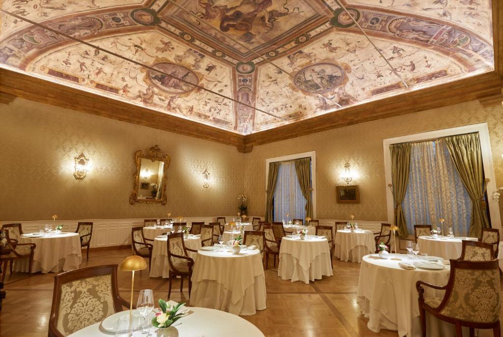 a dining room with tables and chairs and a ceiling at Grand Hotel Majestic gia' Baglioni in Bologna