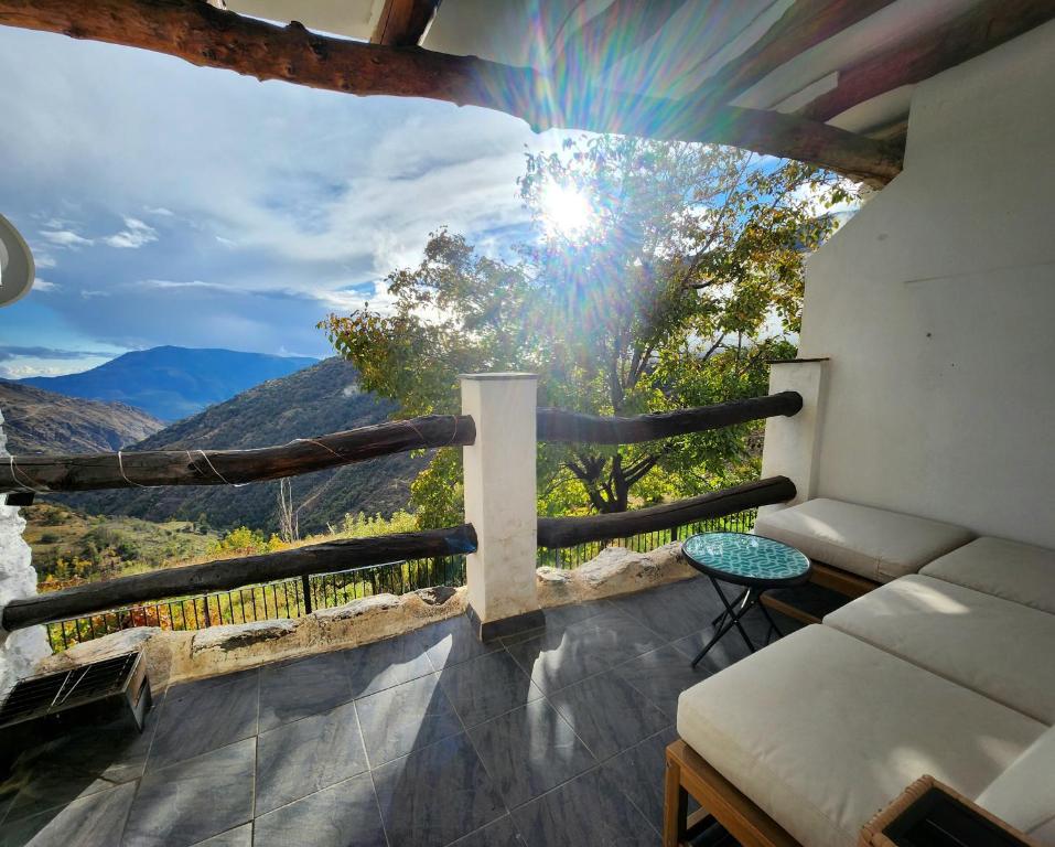 a balcony with a couch and a view of the mountains at San Roque in Capileira