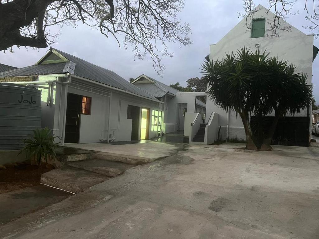 una casa bianca con una palma in un vialetto di Heba Guest Lodge Two a Uitenhage