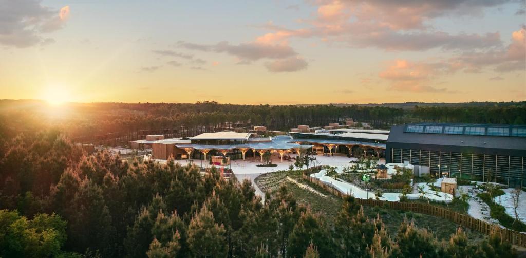 an aerial view of a building with the sun setting at Center Parcs Les Landes de Gascogne in Beauziac
