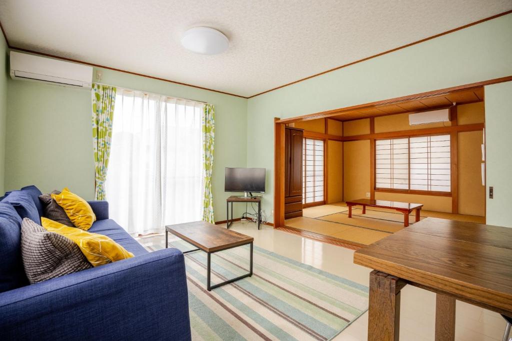 a living room with a blue couch and a table at Twilight Villa Onjuku - Vacation STAY 52776v in Iwada