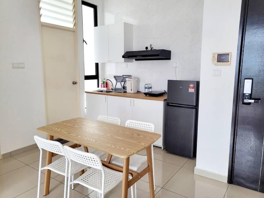 ジョホールバルにあるHaider's Homestay D'Summit Residence Kempas JBのキッチン(木製のテーブル、椅子、冷蔵庫付)