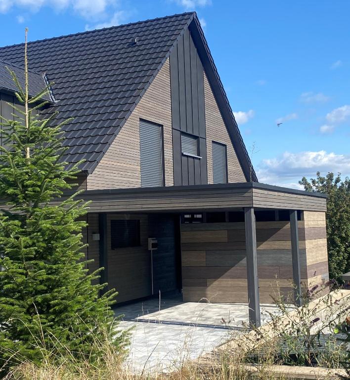 a house with a gambrel roof with a garage at Boarding 9a Wohnen auf Zeit in Eschau