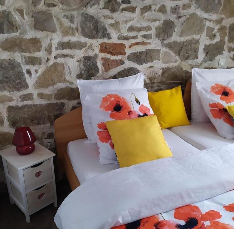 une chambre avec deux lits et un mur en pierre dans l'établissement Nid douillet en ville - l'Atipik, à Mulhouse