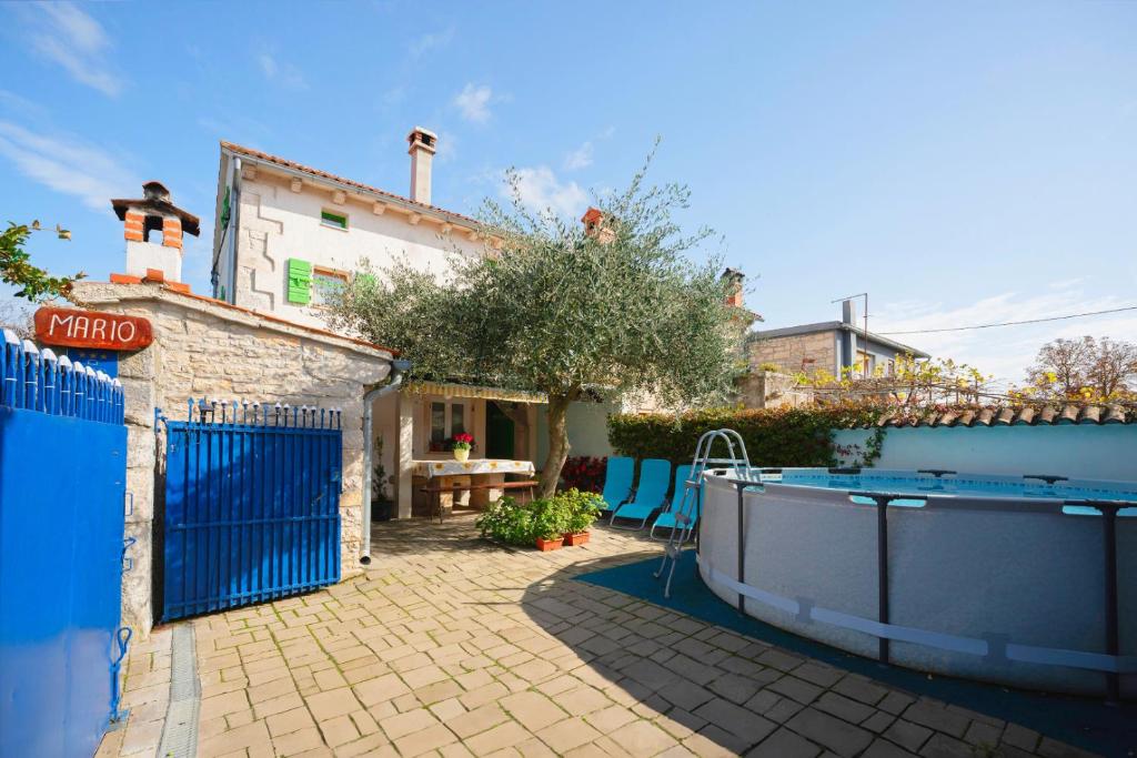 une cour arrière avec une piscine et une maison dans l'établissement Holiday house Mario, à Peresiji