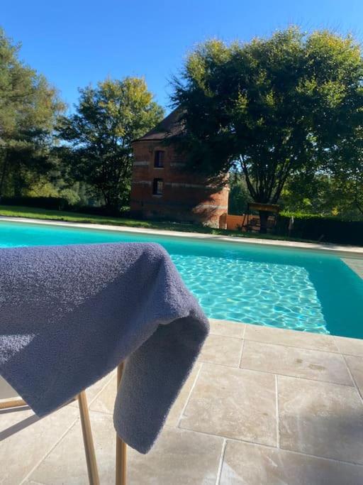 - une serviette assise sur une chaise à côté de la piscine dans l'établissement Le Colombier d Yville, à Héronchelles