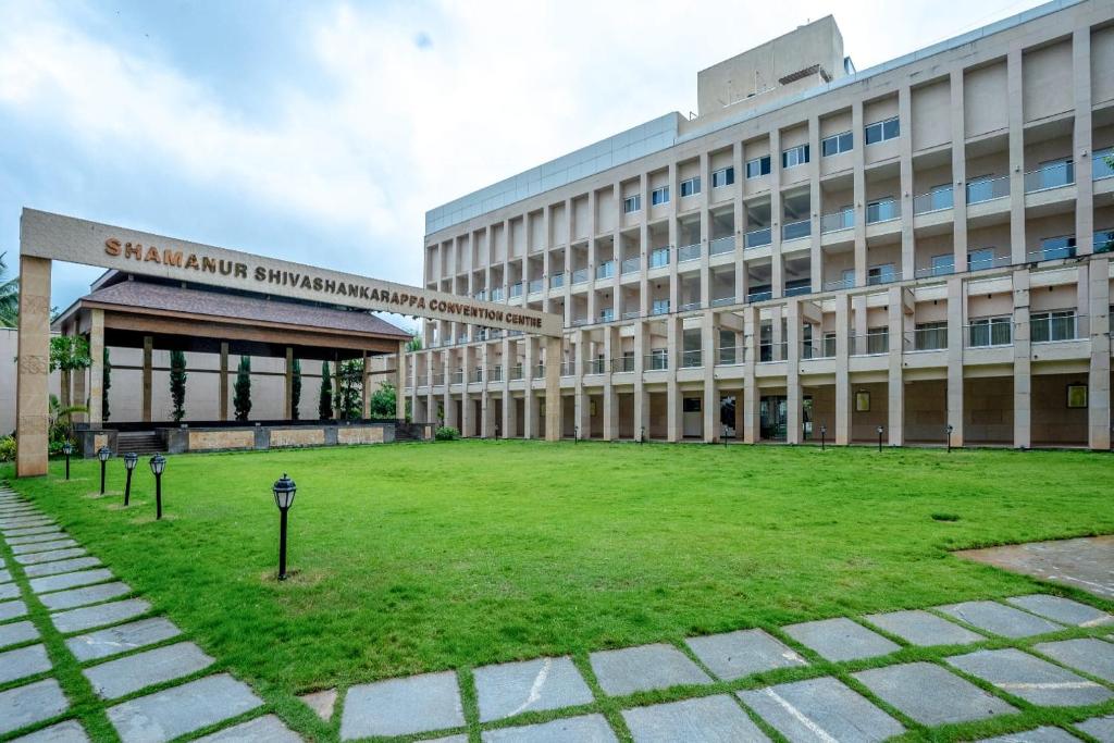 a building with a grass field in front of it at Southern Star,Davangere in Dāvangere