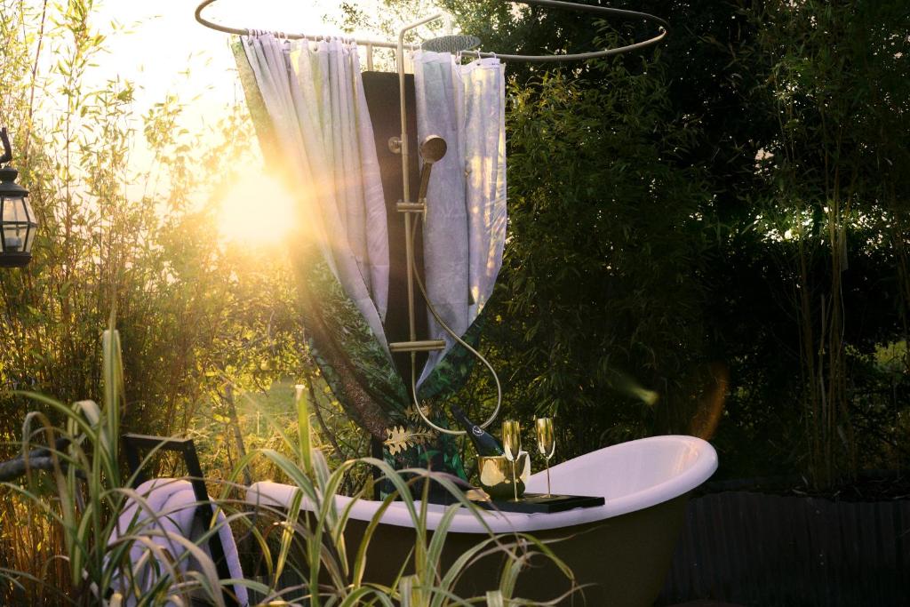 a bath tub with a shower with a curtain at Yellow Egg in Cropthorne