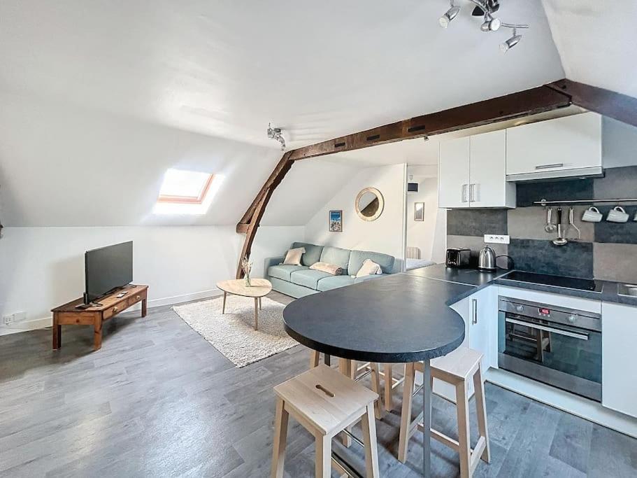 une cuisine et un salon avec une table et un canapé dans l'établissement Le Saint Lazare - proche centre, à Compiègne