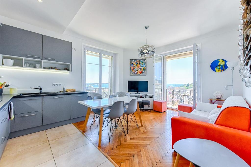 une cuisine et un salon avec un canapé et une table dans l'établissement LE SINATRA splendide vue mer panoramique et balcon, idéal pour des séjours de loisirs ou business, à Cannes