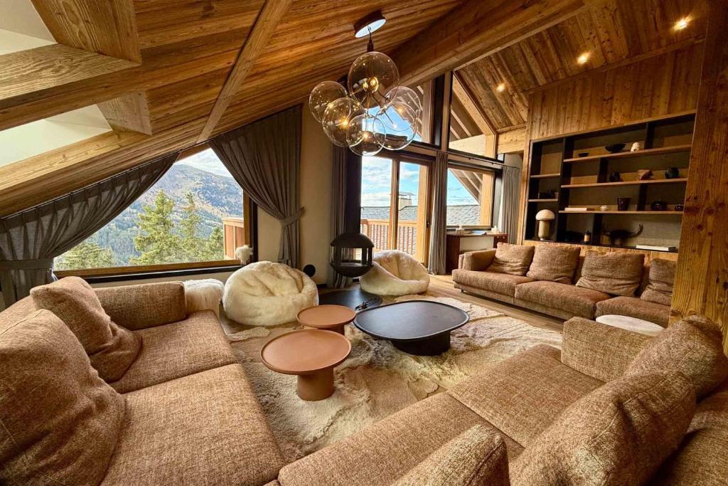 un salon avec un canapé et une grande fenêtre dans l'établissement Antarès URSA 601 - Amazing duplex penthouse ski inout in Méribel, à Méribel