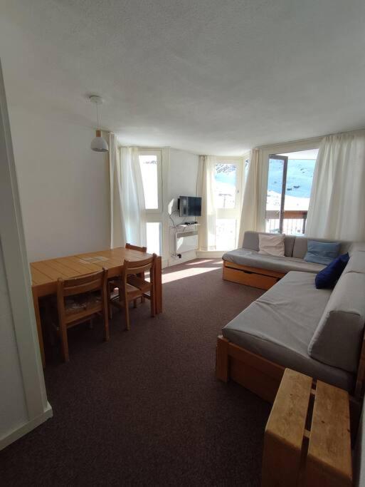 Cette chambre comprend un lit, une table et un canapé. dans l'établissement BOR54 - Joli T3 lumineux 6pers, skis au pieds, à Tignes