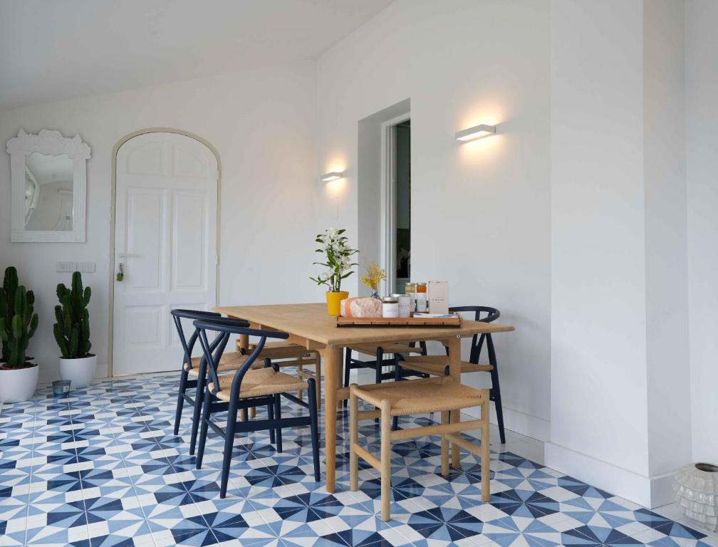 a dining room with a table and chairs on a blue and white floor at Casa Dalù in Positano