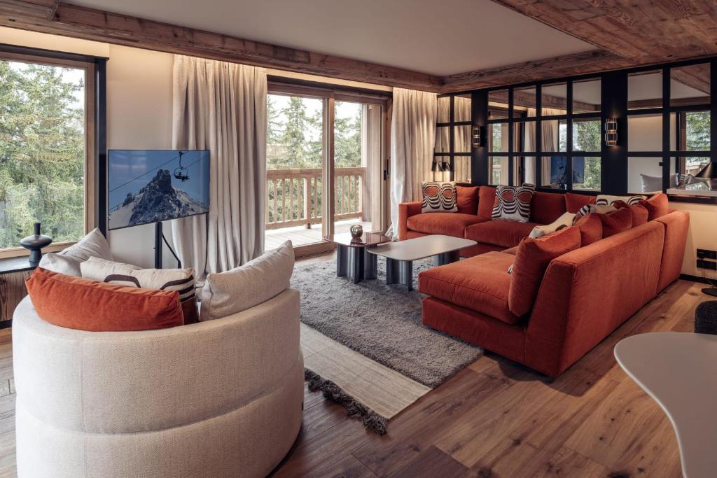 a living room with two couches and a tv at Antarès URSA 402 - luxury apartment ski inski out in Méribel