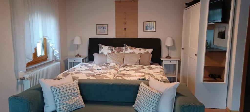 a bedroom with a bed with a blue couch and pillows at Ferienunterkünfte Schüle in Leibertingen