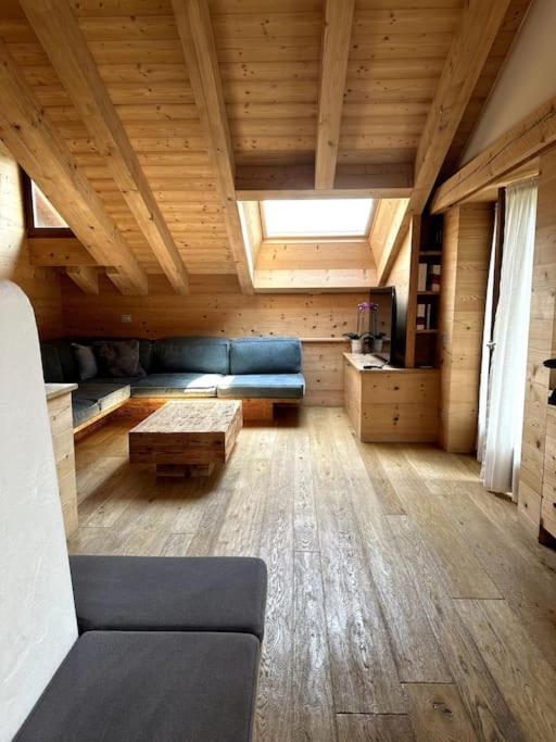 un soggiorno con un divano e un tavolo di Attico Bellavista a Cortina dʼAmpezzo