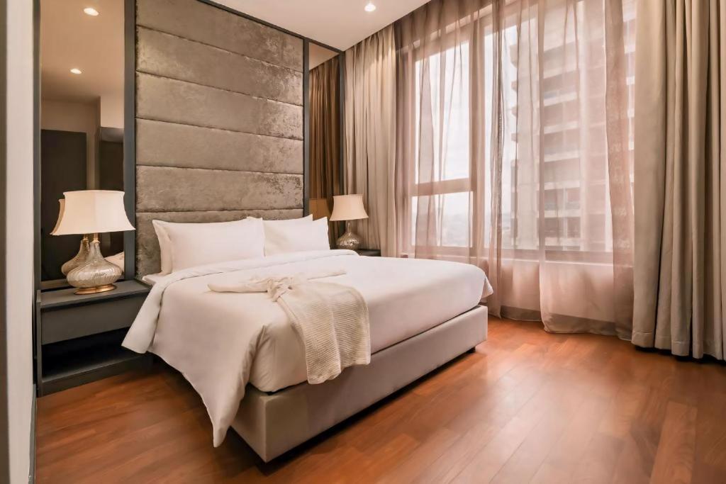 une chambre avec un grand lit et une grande fenêtre dans l'établissement 8 Kia Peng Suites KLCC by Luna, à Kuala Lumpur