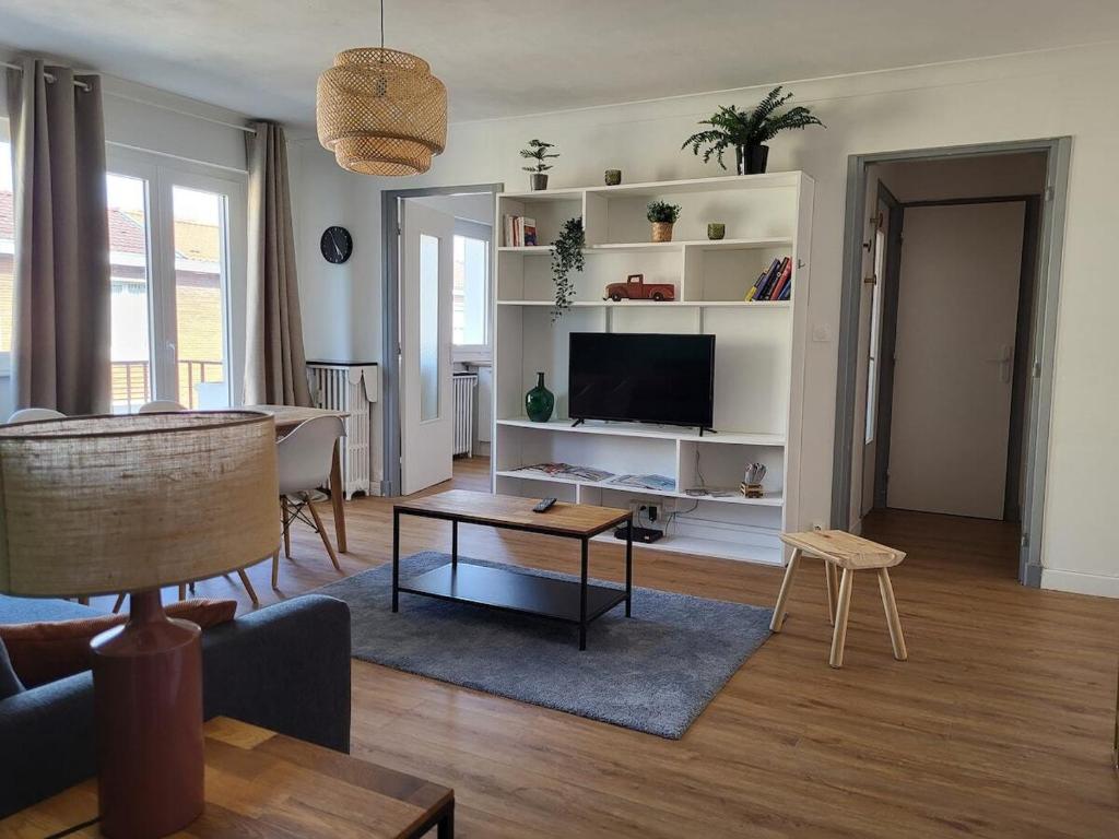 un salon avec un canapé, une table et une télévision dans l'établissement Appart Cosy parking privé Croisé Laroche près tram, à Marcq-en-Barœul