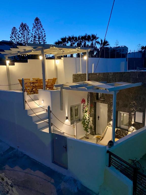 a white house with stairs and umbrellas at night at Euphemus Cave House in Mesaria