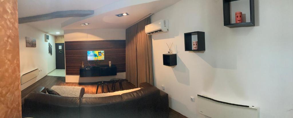 un soggiorno con un divano e un tavolo di Apartman 11 a Leskovac