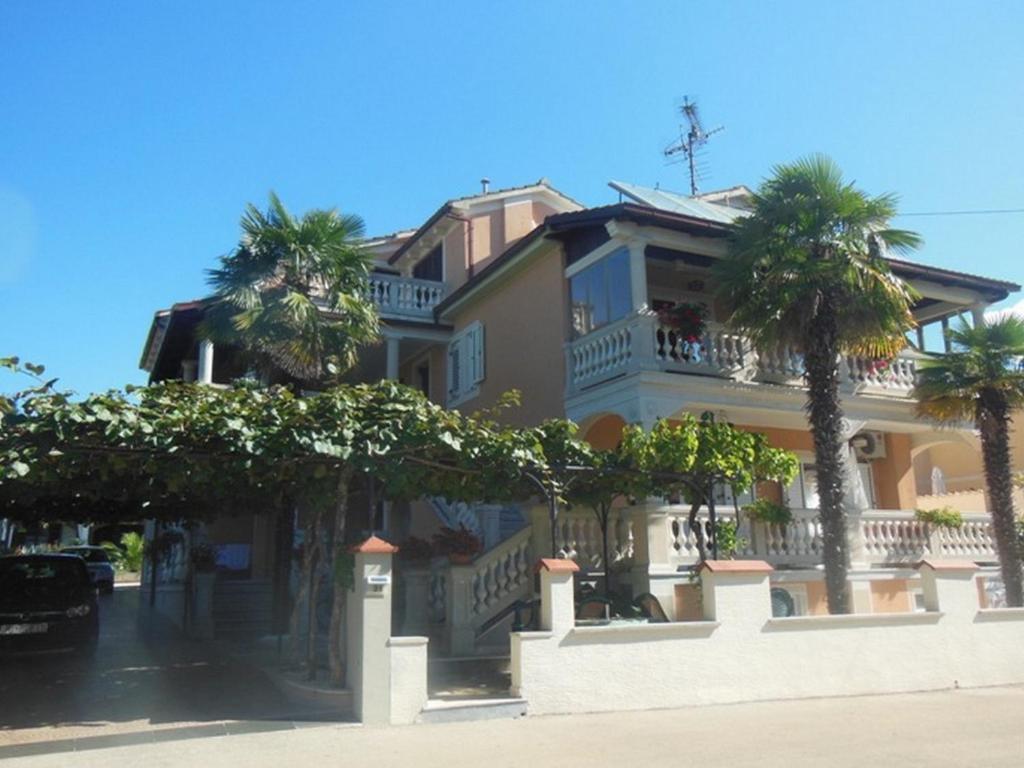 een groot huis met palmbomen ervoor bij House Alma in Poreč