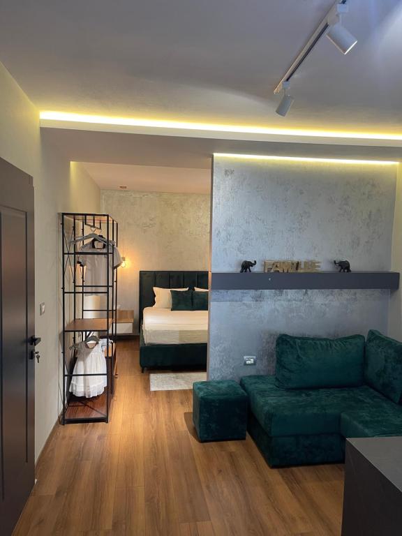 a living room with a green couch and a bed at Melnaz Apartament 2 in Korçë