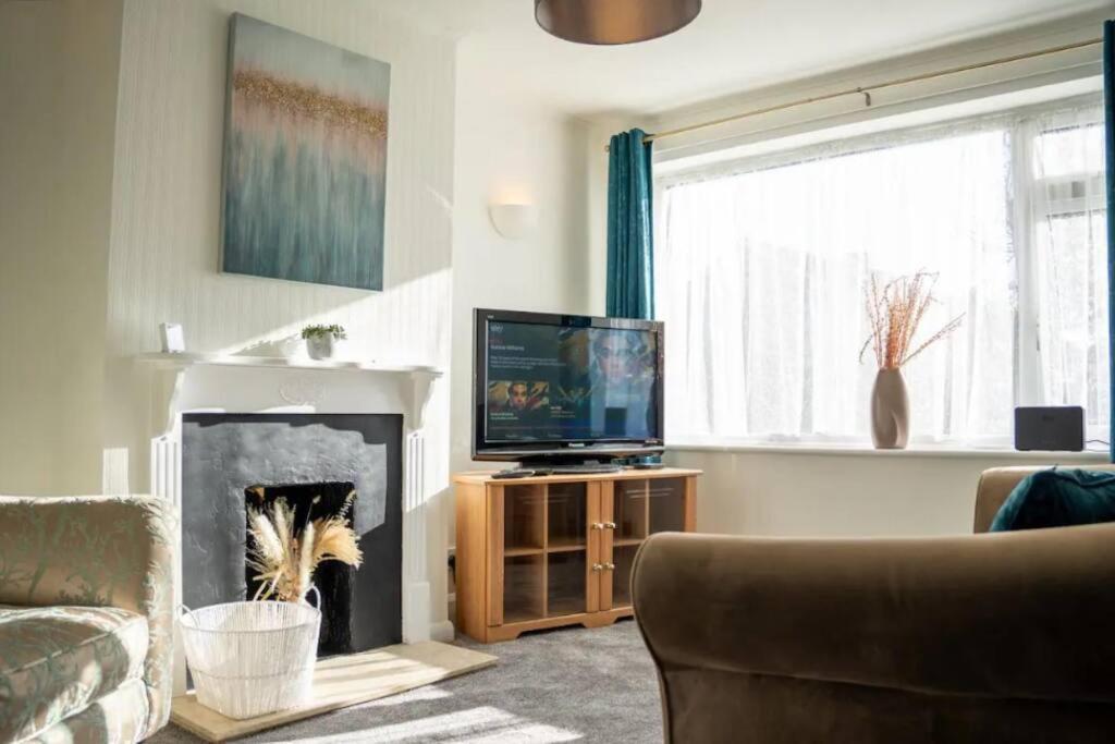 ミルトン・キーンズにある3 Bedroom home in Milton Keynes with Free Parking, WiFi and SKY TVのリビングルーム(暖炉、テレビ付)