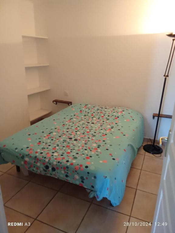 un lit avec des aspersions dans une pièce dans l'établissement Proche du centre ville, à Aigues-Mortes