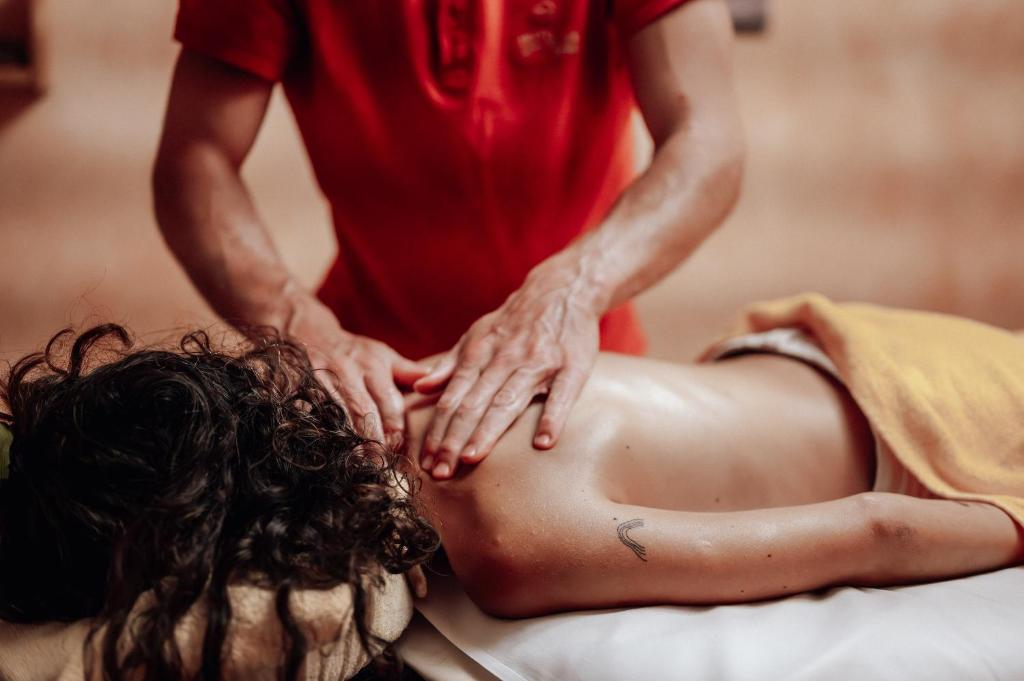 a woman getting a back massage on a bed at Hotel Goldener Berg in Lech am Arlberg