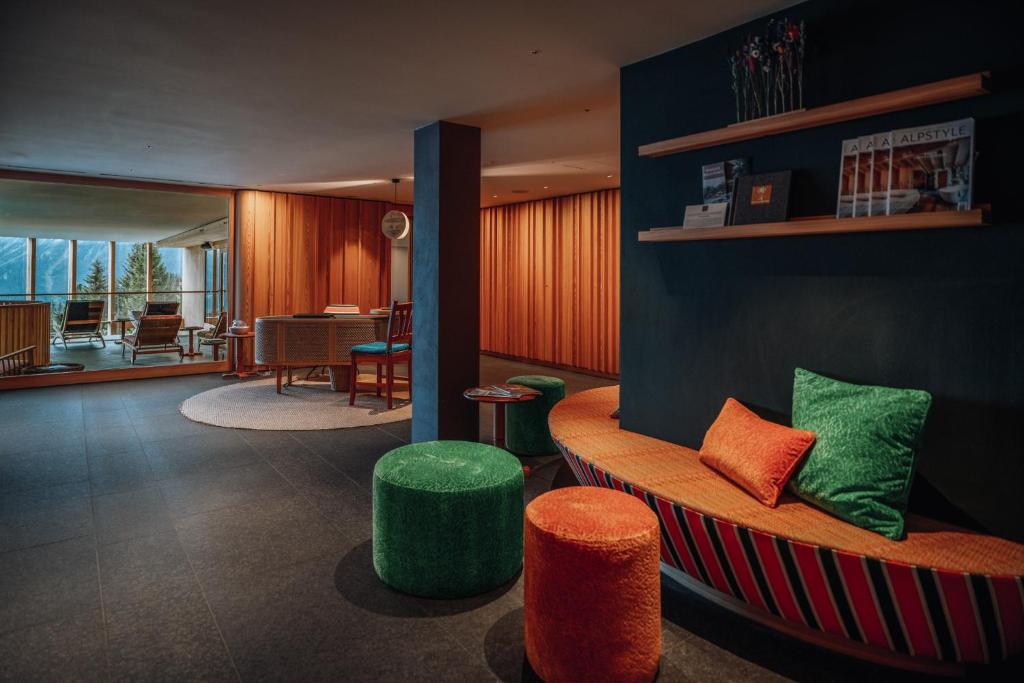 a lobby with a bench with green and orange seats at Hotel Goldener Berg in Lech am Arlberg