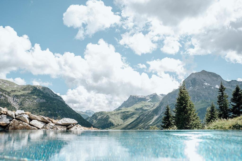 a view of a lake with mountains in the background at Hotel Goldener Berg in Lech am Arlberg