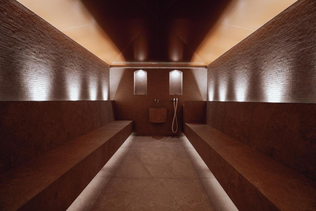 a hallway of a bathroom with a urinal and lights at Hotel Goldener Berg in Lech am Arlberg