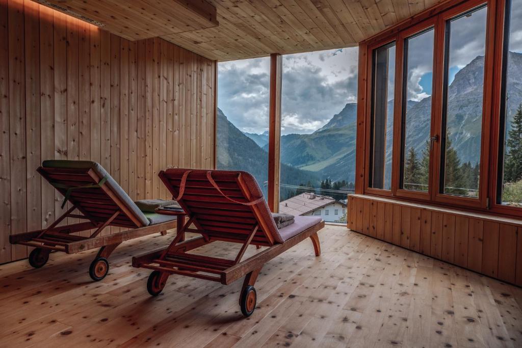 two chairs in a room with a view of mountains at Hotel Goldener Berg in Lech am Arlberg
