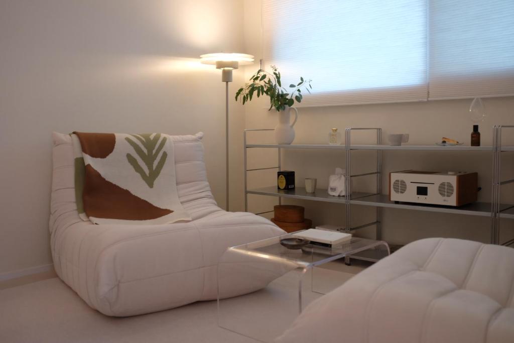 a living room with a white couch and a table at Red letter day #Dongdaemun #Seongsu #Hanyangdae #Ttukseom #SubwayStreet 5 minutes #netflix #emotional #legalhome in Seoul